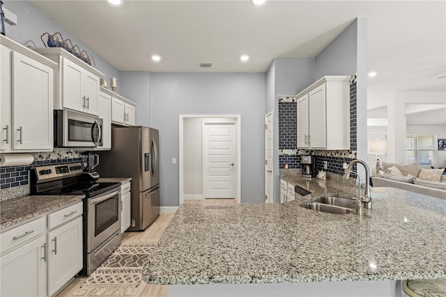 kitchen featuring appliances with stainless steel finishes, a sink, and white cabinets