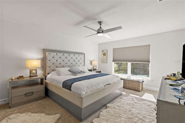 bedroom with ceiling fan, baseboards, and light colored carpet