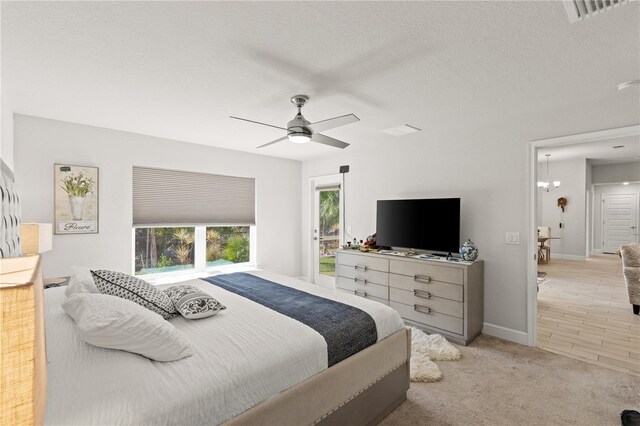 bedroom featuring carpet, visible vents, ceiling fan, a textured ceiling, and baseboards