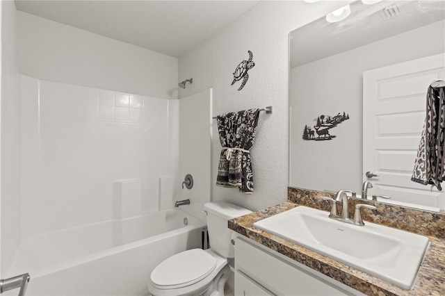 bathroom featuring a textured wall, shower / tub combination, vanity, and toilet