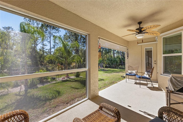 sunroom / solarium featuring ceiling fan and a wealth of natural light