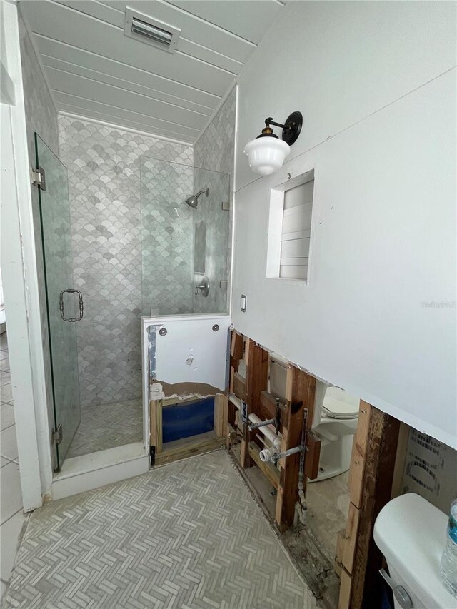 bathroom with toilet and a shower with door