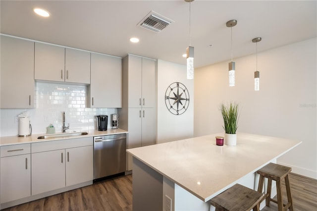 kitchen with dark hardwood / wood-style flooring, dishwasher, decorative light fixtures, and sink