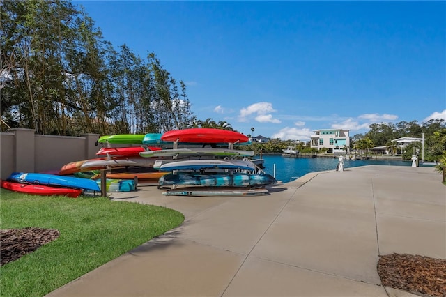 view of swimming pool with a lawn, a dock, and a water view