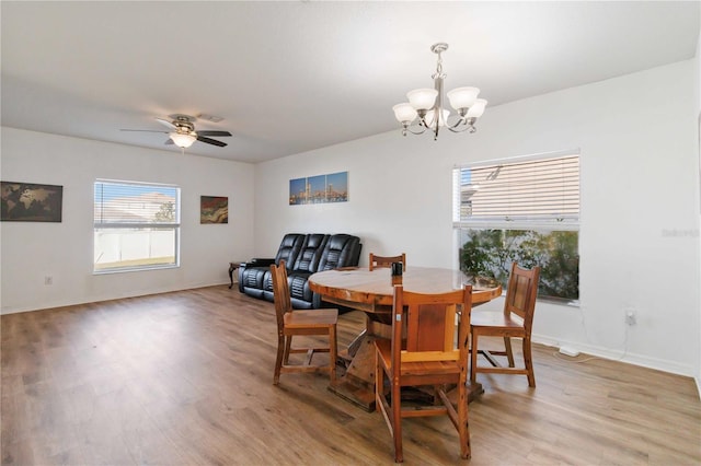 dining area featuring ceiling fan with notable chandelier and light hardwood / wood-style floors