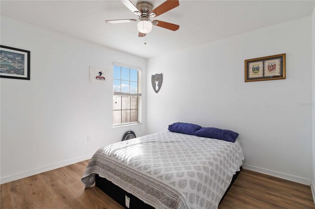 bedroom with ceiling fan and dark hardwood / wood-style floors