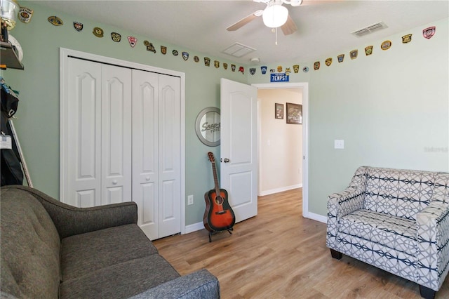 living area featuring light hardwood / wood-style floors and ceiling fan