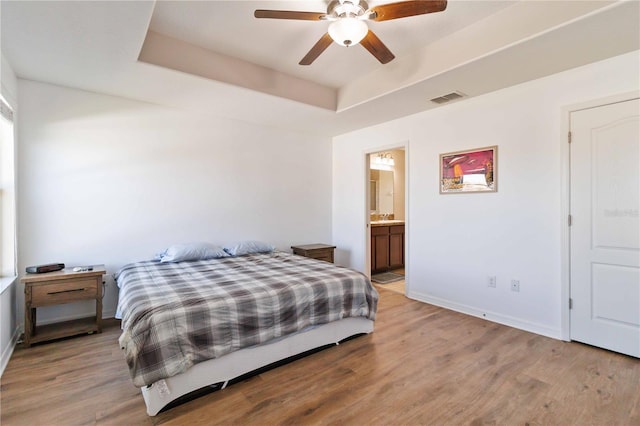 bedroom featuring light wood-type flooring, ensuite bath, and ceiling fan