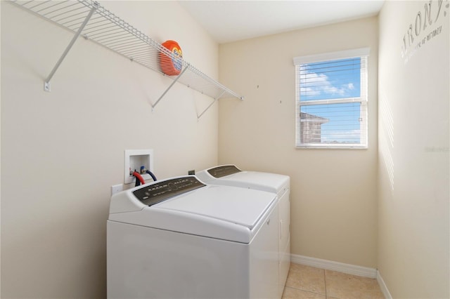 washroom featuring washer and clothes dryer and light tile patterned flooring