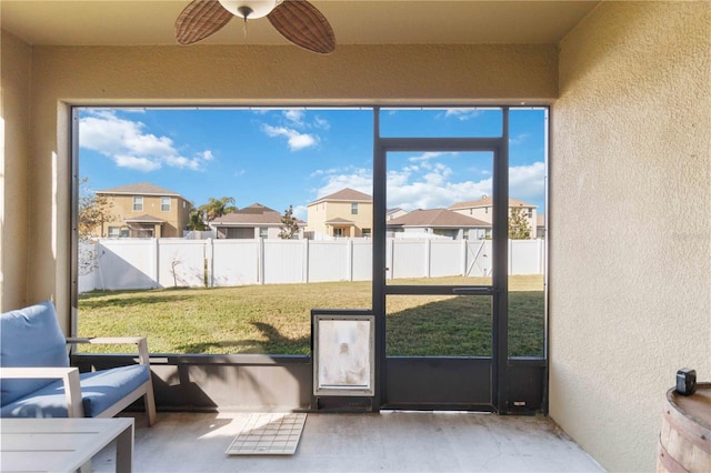 unfurnished sunroom with ceiling fan