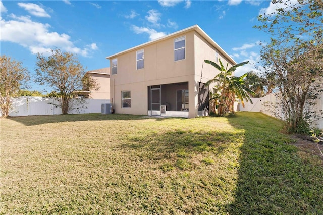 back of house with a yard and central air condition unit