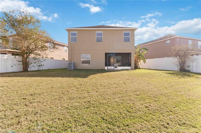 back of house featuring central AC unit and a yard