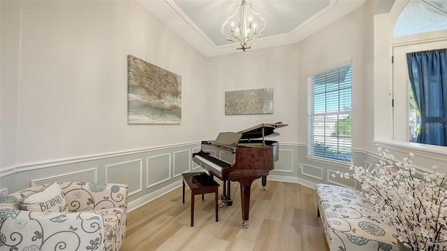 misc room featuring light wood-type flooring, ornamental molding, and a chandelier