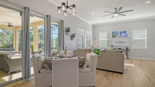 living room featuring ornamental molding, ceiling fan with notable chandelier, and light wood-type flooring