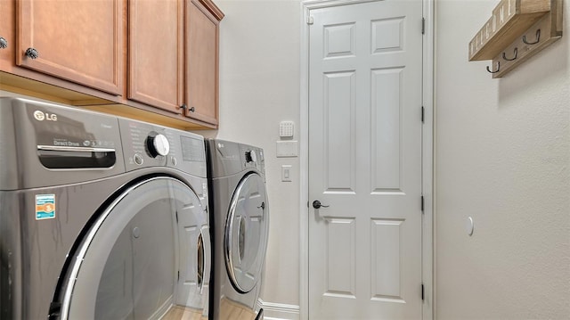 laundry room with washer and clothes dryer and cabinets