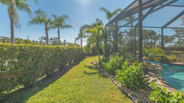 view of yard featuring a fenced in pool and glass enclosure