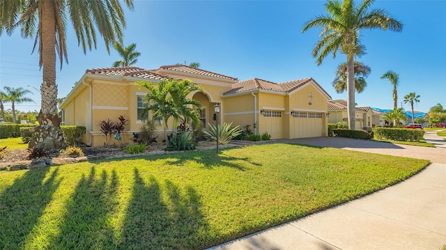 mediterranean / spanish home with a garage and a front lawn