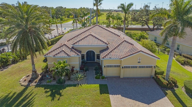 mediterranean / spanish-style home with a front yard and a garage