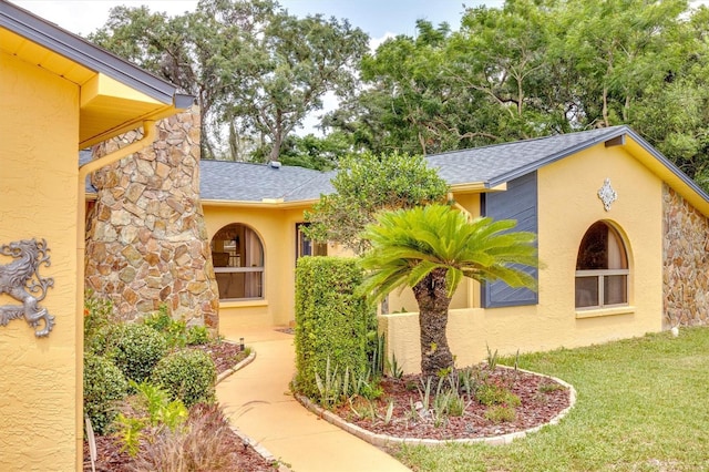 doorway to property with a lawn