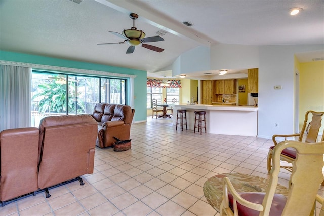 tiled living room featuring lofted ceiling with beams and ceiling fan