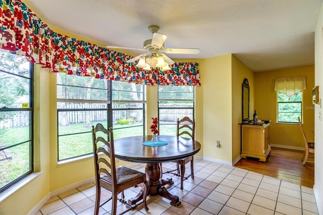 dining area with ceiling fan, light tile patterned flooring, and a textured ceiling