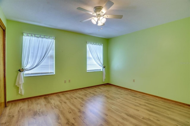 spare room with light wood-type flooring and ceiling fan