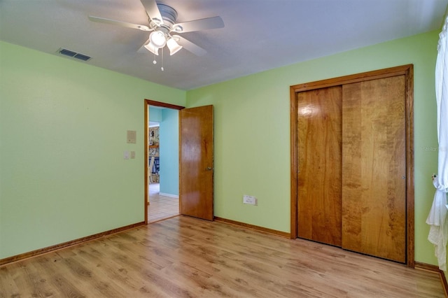 unfurnished bedroom with light wood-type flooring, a closet, and ceiling fan