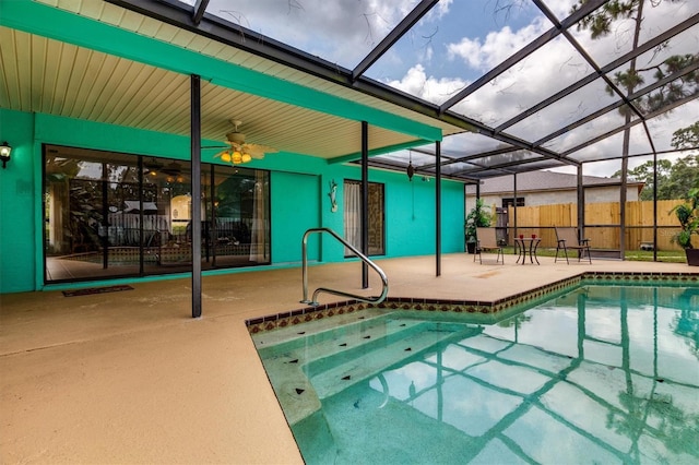 view of swimming pool with ceiling fan, a lanai, and a patio