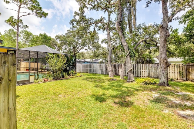 view of yard featuring glass enclosure and a fenced in pool