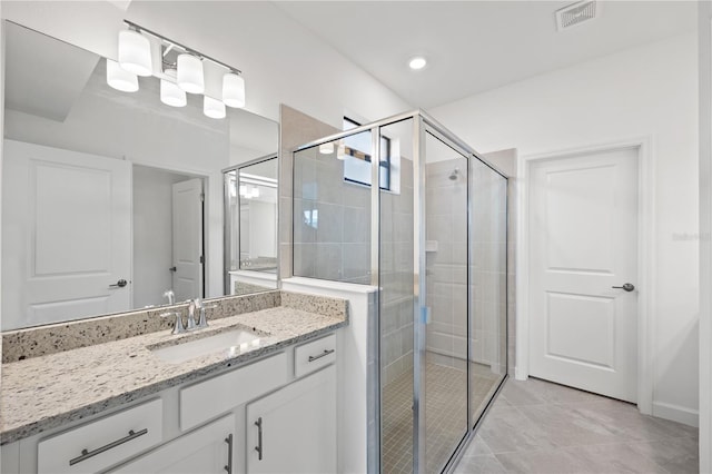 bathroom featuring a shower with door, vanity, and tile patterned flooring