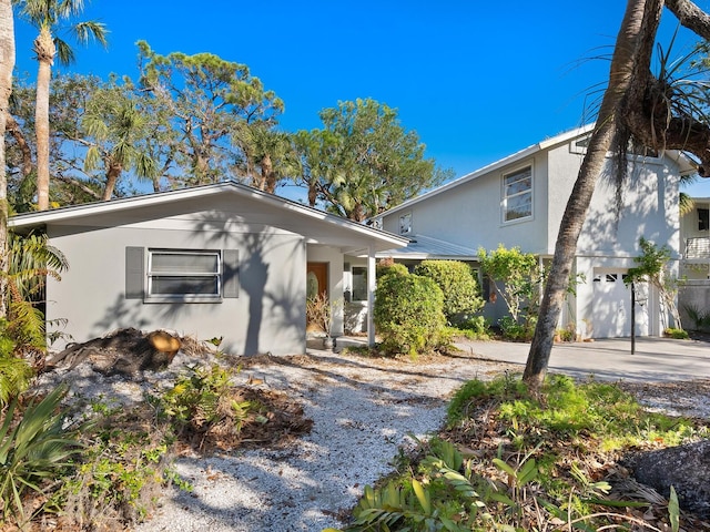 view of front of home with stucco siding, concrete driveway, and an attached garage