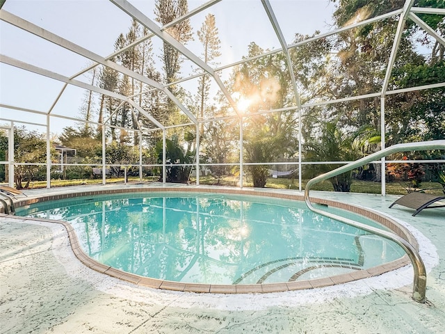 view of swimming pool featuring glass enclosure and a patio