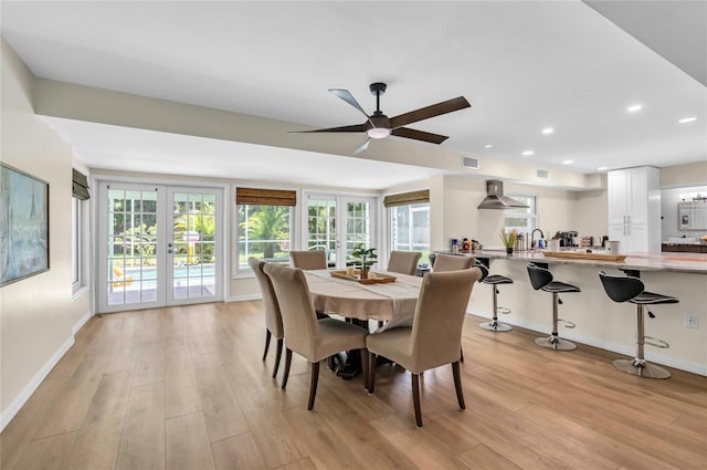 dining area featuring french doors, a wealth of natural light, and light hardwood / wood-style flooring