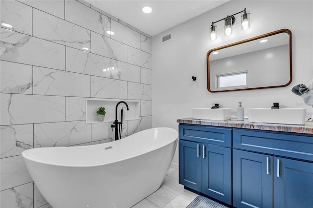 bathroom with a washtub, vanity, and tile walls