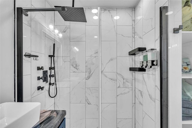 bathroom featuring a shower with door and sink