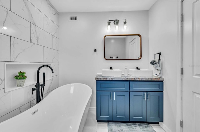 bathroom featuring tile patterned floors, a bathtub, and vanity