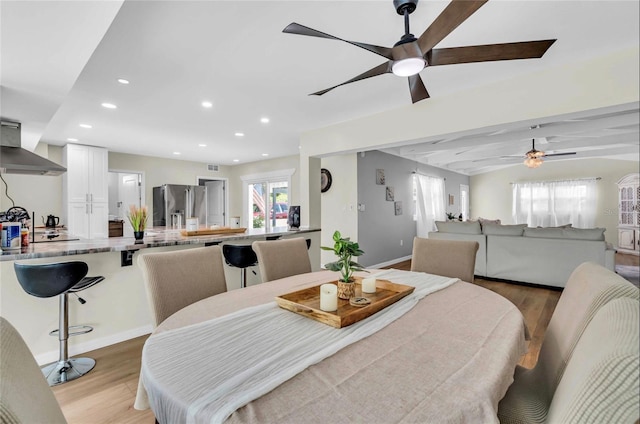 dining area featuring beamed ceiling, ceiling fan, and light hardwood / wood-style flooring