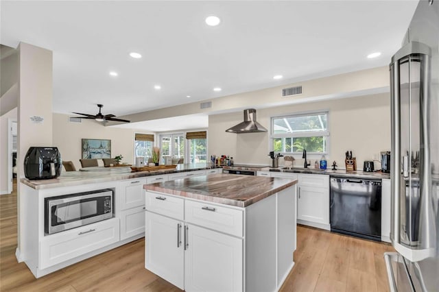 kitchen featuring kitchen peninsula, a center island, light wood-type flooring, and stainless steel appliances