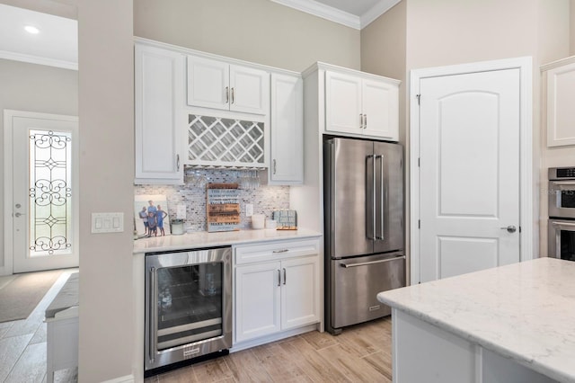 kitchen featuring light stone countertops, stainless steel appliances, light hardwood / wood-style flooring, white cabinets, and wine cooler