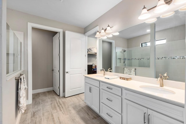 bathroom with a tile shower, vanity, and hardwood / wood-style flooring