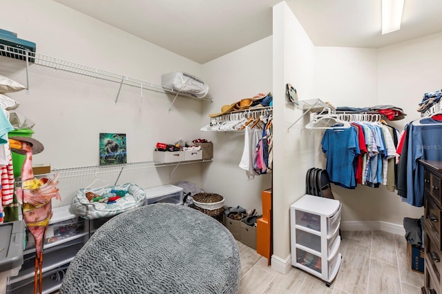 walk in closet with light wood-type flooring