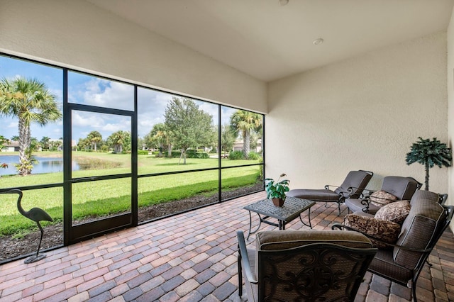 sunroom featuring a water view