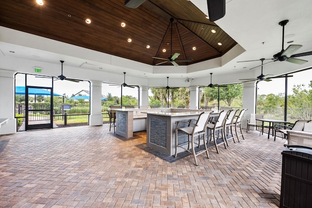 view of patio with ceiling fan and an outdoor bar