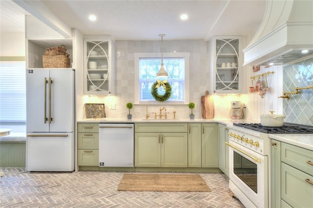 kitchen featuring sink, hanging light fixtures, premium range hood, decorative backsplash, and high end appliances