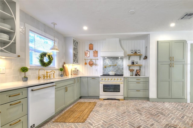 kitchen with tasteful backsplash, custom exhaust hood, white appliances, pendant lighting, and green cabinetry