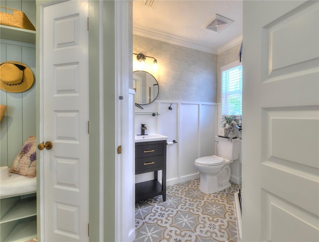 bathroom with tile patterned flooring, vanity, toilet, and crown molding