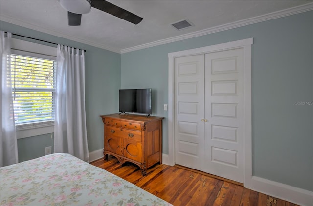 bedroom with a closet, ceiling fan, hardwood / wood-style floors, and ornamental molding