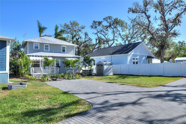 view of front of property featuring a front yard, a porch, and a storage unit