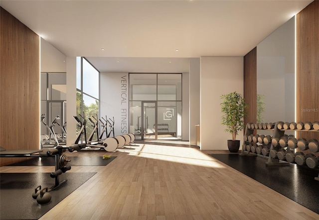 exercise room with floor to ceiling windows and hardwood / wood-style floors