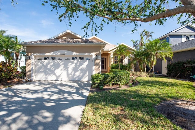 ranch-style house with a garage and a front lawn